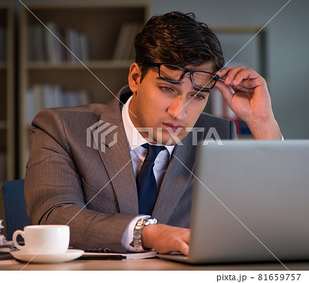 Businessman staying in the office for long hours Businessman staying in the office for long hours 81659757