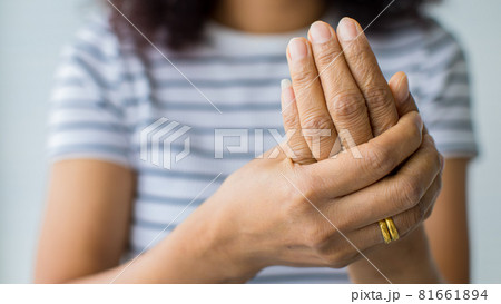 Women in using hand to hold palm and fingers with feeling pain, suffer, hurt and tingling. Concept of Guillain barre syndrome and numb hands disease Women in using hand to hold palm and fingers with feeling pain, suffer, hurt and tingling. Concept of Guillain barre syndrome and numb hands disease 81661894