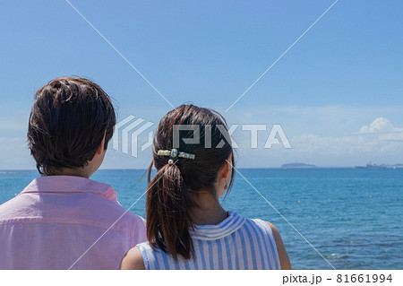 夏の海辺のカップル後ろ姿の写真素材