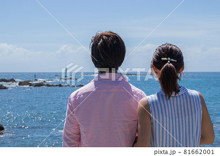 夏の海辺のカップル後ろ姿の写真素材