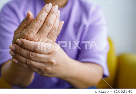 Woman using hand to hold other of her hand with feeling pain, hurt and tingling. Concept of Guillain barre syndrome and numb hands disease Woman using hand to hold other of her hand with feeling pain, hurt and tingling. Concept of Guillain barre syndrome and numb hands disease 81662249
