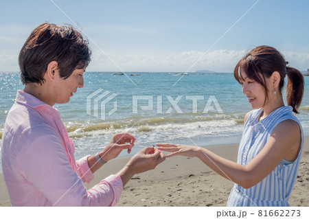 晴れた夏の海辺で指輪を渡すカップル 晴れた夏の海辺で指輪を渡すカップル 81662273