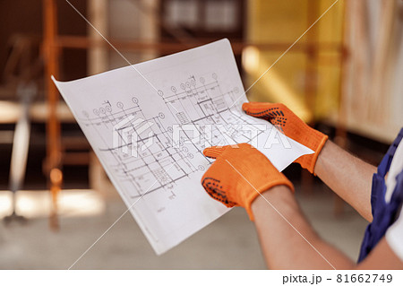 Male worker hands in gloves holding architectural plan Male worker hands in gloves holding architectural plan 81662749