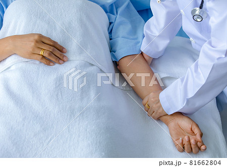 Doctor hold hand of patient on bed in hospital and checkup nervous system for cure and treatment. Concept of Guillain barre syndrome and numb hands disease or vaccine side effect Doctor hold hand of patient on bed in hospital and checkup nervous system for cure and treatment. Concept of Guillain barre syndrome and numb hands disease or vaccine side effect 81662804