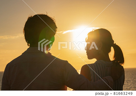 夕暮れの海辺で愛を語るカップル 81663249