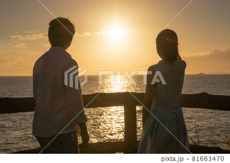 夏の夕日の海辺の若いカップル 81663470