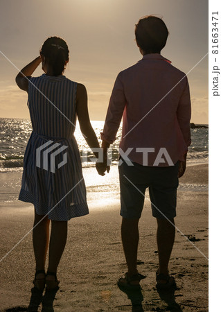 夏の夕日の海辺の若いカップル 夏の夕日の海辺の若いカップル 81663471