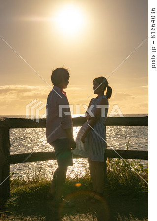 夏の夕暮れの海辺で向かい合うカップル 81664036