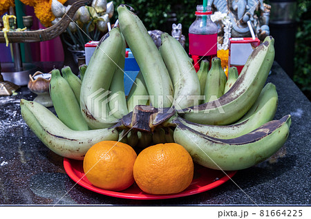 Raw bananas and oranges on a red tray For worship The thao maha phrom shrineis. Raw bananas and oranges on a red tray For worship The thao maha phrom shrineis. 81664225