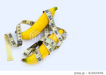 Banana wrapped in measuring tape on white background. 81664946
