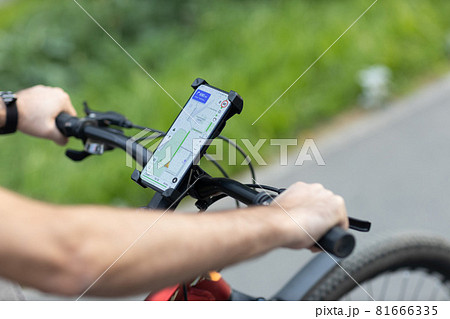 Man planning route using GPS navigation application in mobile phone on his bicycle bike. 81666335