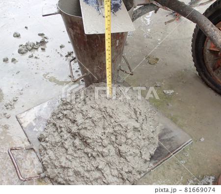 KUALA LUMPUR, MALAYSIA -DECEMBER 23, 2015: Construction workers doing slump test using specific equipment at the construction site. Witness by consultant. KUALA LUMPUR, MALAYSIA -DECEMBER 23, 2015: Construction workers doing slump test using specific equipment at the construction site. Witness by consultant. 81669074