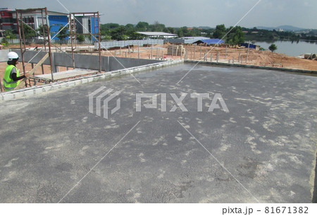SELANGOR, MALAYSIA -SEPTEMBER, 2014: Construction worker apply layer of bituminous waterproofing at the building roof slab surface. SELANGOR, MALAYSIA -SEPTEMBER, 2014: Construction worker apply layer of bituminous waterproofing at the building roof slab surface. 81671382
