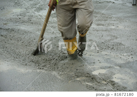 JASIN, MALAYSIA -NOVEMBER 13, 2015: Construction worker leveling wet concrete has been poured. They also use a vibrator machine in this work. JASIN, MALAYSIA -NOVEMBER 13, 2015: Construction worker leveling wet concrete has been poured. They also use a vibrator machine in this work. 81672180