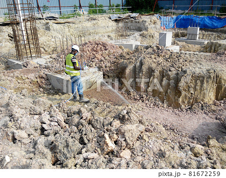 JOHOR, MALAYSIA -MARCH 29, 2016: Construction workers spraying the anti termite chemical treatment to the soil at the construction site. JOHOR, MALAYSIA -MARCH 29, 2016: Construction workers spraying the anti termite chemical treatment to the soil at the construction site. 81672259