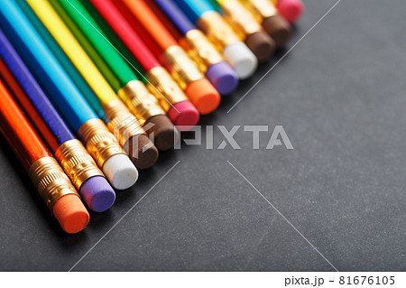 Colorful pencils with erasers in a row on a black background Colorful pencils with erasers in a row on a black background 81676105