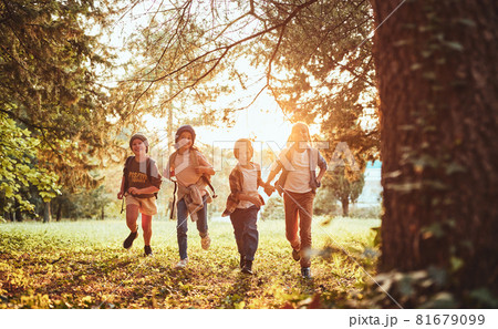 Excited children with backpacks enjoying walk in forest on sunny autumn day, kids exploring nature 81679099