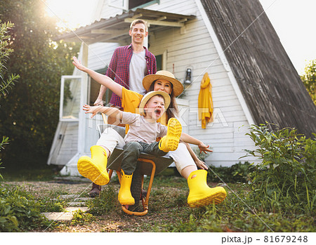 Excited family playing with wheelbarrow Excited family playing with wheelbarrow 81679248