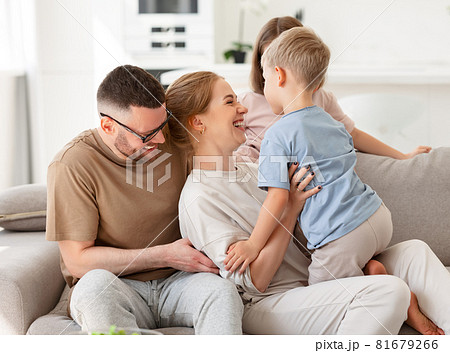 Happy beautiful family having fun and playing while relaxing on sofa in living room 81679266