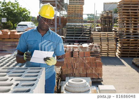 Man worker controlling quantity of bricks at hardware store 81686048