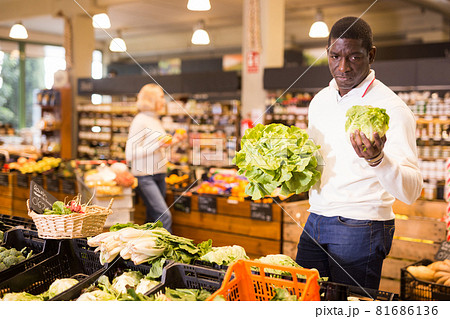 Man looking for vegetables in grocery store 81686136