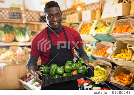Salesman carrying box with green peppers 81686248