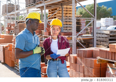 Man and woman talking in construction material storage Man and woman talking in construction material storage 81690311