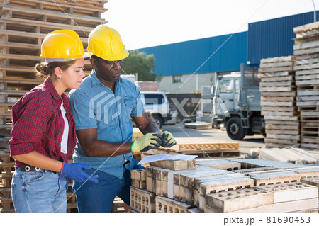 Couple of wokers checking order list at hardware store 81690453
