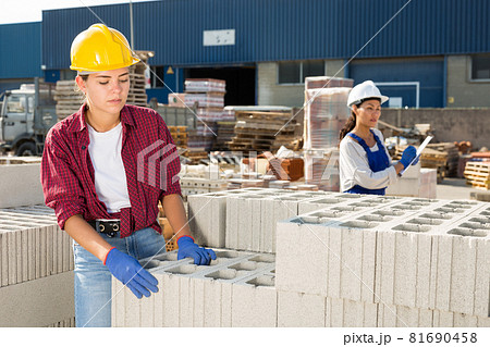 Woman checking quality of bricks at construction store Woman checking quality of bricks at construction store 81690458