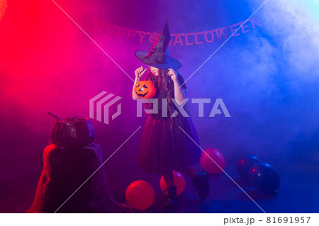 Funny child girl in witch costume for Halloween with pumpkin Jack. Funny child girl in witch costume for Halloween with pumpkin Jack. 81691957