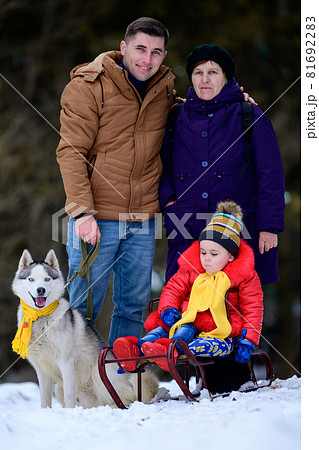 Family in the third generation grandmother, son and granddaughter in the winter forest, their husky dog, sleigh girl. Family in the third generation grandmother, son and granddaughter in the winter forest, their husky dog, sleigh girl. 81692283
