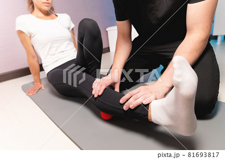 Physiotherapist teaches self-massage with red balls, patient with leg injury. Treatment of sports injuries. Practical use. Rehabilitation concept. Physiotherapist teaches self-massage with red balls, patient with leg injury. Treatment of sports injuries. Practical use. Rehabilitation concept. 81693817