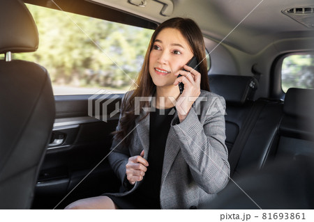 business woman talking on mobile phone while sitting in the back seat of car business woman talking on mobile phone while sitting in the back seat of car 81693861