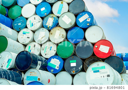 Old chemical barrels with flammable liquid warning label . Steel oil tank. Toxic waste in metal tank. Hazardous chemical barrel. Hazard waste storage in factory. Chemical barrels stack. Oil brent. 81694801