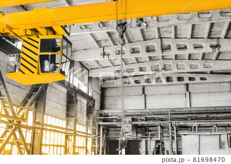 Overhead crane hoist equipment in an industrial plant transports an iron rail on lifting chain Overhead crane hoist equipment in an industrial plant transports an iron rail on lifting chain 81698470