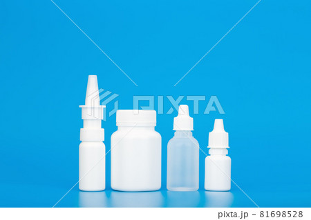 Set of medications, pills and ear drops on podium and eye drops and nose spray against blue background with copy space 81698528