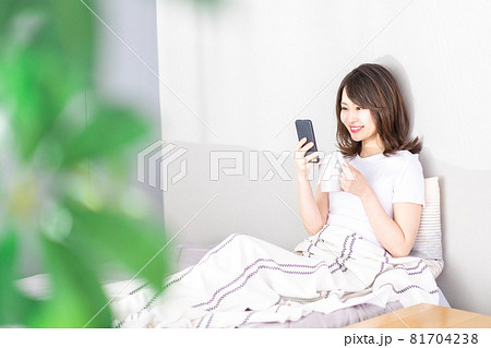 ベッドでスマホを使う若い女性 ベッドでスマホを使う若い女性 81704238