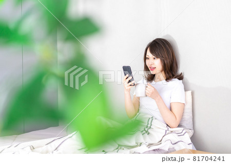 ベッドでスマホを使う若い女性 ベッドでスマホを使う若い女性 81704241