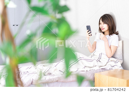 ベッドでスマホを使う若い女性 ベッドでスマホを使う若い女性 81704242