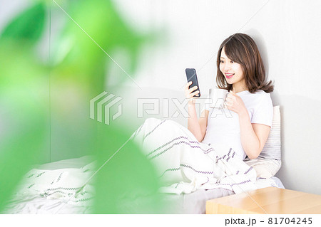 ベッドでスマホを使う若い女性 ベッドでスマホを使う若い女性 81704245
