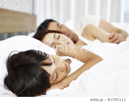 asian couple and child sleeping in bed 81705111