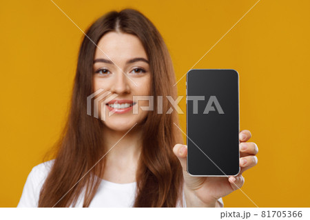 Closeup of beautiful young woman showing cellphone with empty screen 81705366