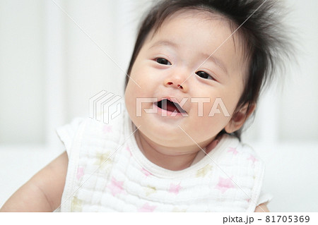 寝返りして遊ぶ0歳4ヶ月の赤ちゃんの写真素材