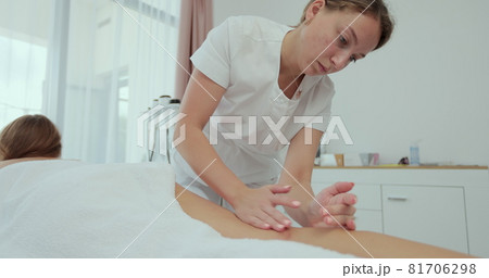 Female massager making body, leg and foot massage and lymphatic drainage. Young woman getting anti-cellulite massage in beauty spa salon. Massage therapist at beauty salon. Female massager making body, leg and foot massage and lymphatic drainage. Young woman getting anti-cellulite massage in beauty spa salon. Massage therapist at beauty salon. 81706298