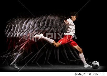 Young professional football player training isolated on black background. Stroboscope effect 81707302