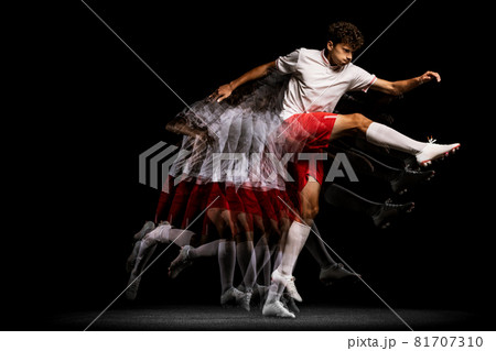 Stroboscope effect. Professional football player isolated on black background playing 81707310