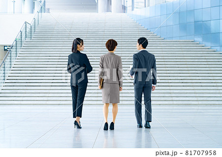 オフィスのエントランスを歩くスーツ姿の男女のビジネスチーム オフィスのエントランスを歩くスーツ姿の男女のビジネスチーム 81707958