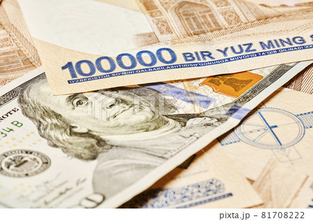US dollar banknote and Uzbek sums. Concept of exchange rate, Uzbek sum to us dollar. Money exchange in Uzbekistan. Pile of Uzbek money sum and American dollar bill 81708222