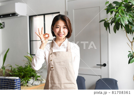 室内にいる笑顔のエプロン姿の若い女性 81708361