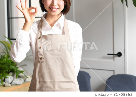 室内にいる笑顔のエプロン姿の若い女性 室内にいる笑顔のエプロン姿の若い女性 81708362